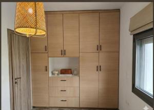 a kitchen with wooden cabinets and a chandelier at Olea Heaven Aliveri in Aliveri