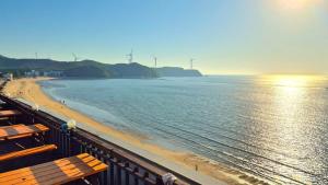 a view of a beach with benches and the ocean at Yeongheungdo Haevichi Pension in Incheon