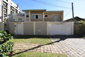 a white fence in front of a house at Loft Jardim Botânico 2 in Curitiba