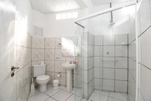 a bathroom with a toilet and a glass shower at Loft Jardim Botânico 2 in Curitiba