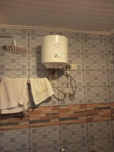 a bathroom with a light and towels on a wall at Studio Residence OR Tambo in Kribi
