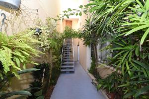 a hallway with a staircase in a building with plants at Loft Jardim Botânico 2 in Curitiba