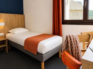 a small room with a bed and a window at Hôtel Hélianthe in Lourdes +39 photos