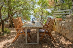 a table and two chairs sitting next to a stone wall at Holiday Home Baricevic in Posedarje +33 photos