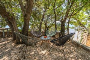 two chairs and a table sitting between two trees at Holiday Home Baricevic in Posedarje