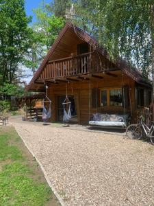 a log cabin with a porch and a balcony at Dream Forest Cabin -dom w lesie pod Warszawą in Warsaw