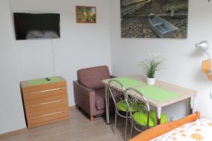 a living room with a table and a chair and a desk at Dworek in Swarzewo
