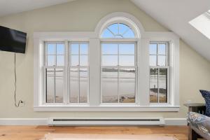 a living room with three windows and a television at Robbins Nest in Essex