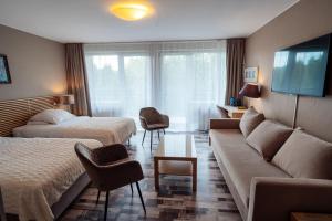a hotel room with two beds and a couch at Hotel New Wave Wisła in Wisła