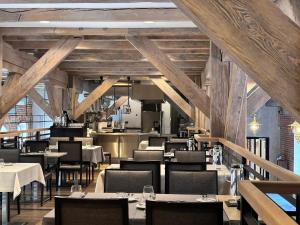 a restaurant with tables and chairs and wooden ceilings at Michaelson Boutique Hotel & SPA Brícoła in Klaipėda