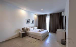 a white bedroom with a bed and a television at Large 3BR Flat with Exceptional Marina Views in Tal-Pietà