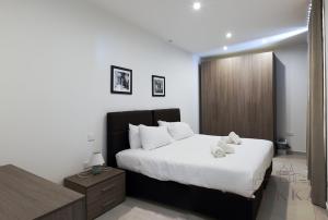 a bedroom with a large bed with white sheets at Large 3BR Flat with Exceptional Marina Views in Tal-Pietà