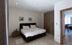 a bedroom with a large bed with white sheets at Large 3BR Flat with Exceptional Marina Views in Tal-Pietà