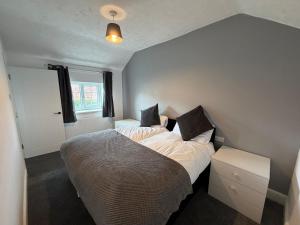 a bedroom with a bed and a window at 3 bed detatched cottage with onsite parking in Rotherham +8 photos