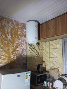 a kitchen with a white refrigerator and a wall at Residence OR Tambo in Kribi +3 photos