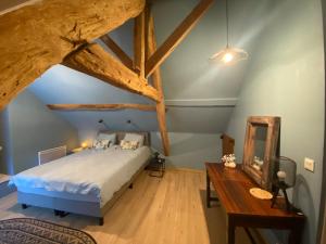 a bedroom with a bed and a wooden floor at Mon Repos, onze sfeervolle gîte in Haims