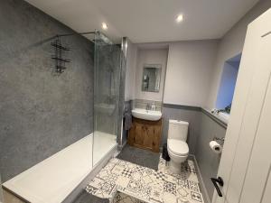 a bathroom with a shower and a toilet and a sink at 3 bed detatched cottage with onsite parking in Rotherham