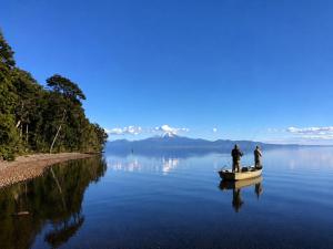 two men fishing on a boat on a lake at Calma Lodge in Puerto Clocker