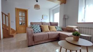 a living room with a brown couch and a table at Casa Anibal in Burón