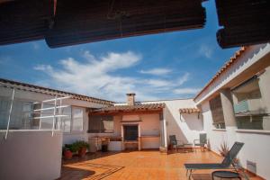 a patio of a house with chairs and tables at Casa La Fuente in Chella