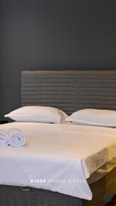 a large bed with two pillows and two towels on it at K1959 Studio Suites in Peje