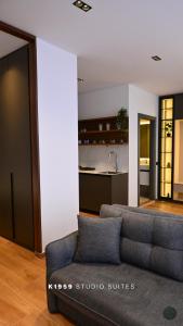 a living room with a couch and a kitchen at K1959 Studio Suites in Peje