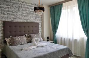a bedroom with a bed with a swan on it at Хотел Брио Велинград in Velingrad