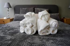 a pile of towels on top of a bed at Хотел Брио Велинград in Velingrad
