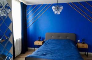 a blue bedroom with a bed with a blue wall at Хотел Брио Велинград in Velingrad +2 photos