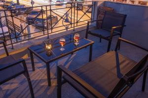 a table and chairs on a balcony with wine glasses at Zoli house in Pefkochori