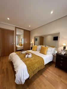 a large bedroom with a large white bed with yellow pillows at Clarens Guesthouse in Cangas del Narcea