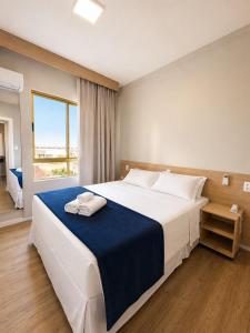 a bedroom with a large bed with a blue blanket at Ingleses Palace Hotel in Florianópolis +40 photos