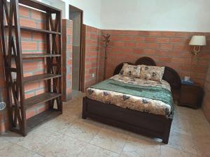 a bedroom with a bed and a brick wall at Guesthouse Nelson L in Quito