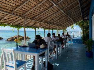 a group of people sitting at tables on the beach at Secret Place Hotel and Restaurant in Haad Yao