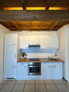a kitchen with white appliances and a wooden ceiling at Ferienwohnung Loft ca. 45 qm in Anröchte