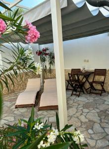 a patio with two beds and a table with flowers at Skalinada in Vir +40 photos