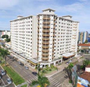a large white building in a city with a parking lot at Boulevard Park in Caldas Novas