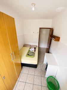 a small room with a bed and a cabinet at Pensão Meg in São José