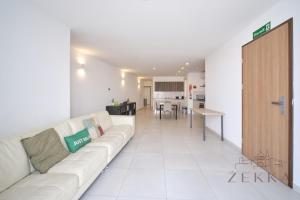 a living room with a white couch and a kitchen at Beautiful View, 3 Bedroom Spacious Apartment in Tal-Pietà