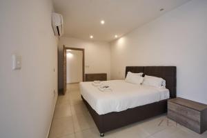 a bedroom with a large bed with white sheets at Beautiful View, 3 Bedroom Spacious Apartment in Tal-Pietà +5 photos