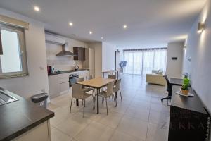 a kitchen and living room with a table and chairs at Beautiful View, 3 Bedroom Spacious Apartment in Tal-Pietà