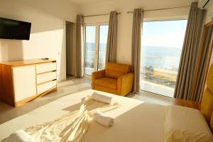 a bedroom with a bed and a chair and a window at Vila Inheritor in Shëngjin +37 photos