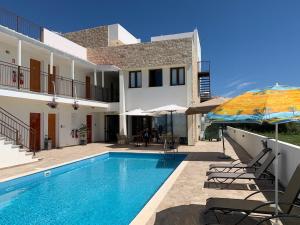 a villa with a swimming pool and a house at Daniel's Hotel Apartments in Paphos