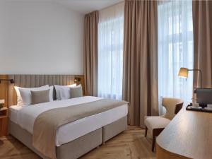 a hotel room with a large bed and windows at DIALOGUE Boutique Hotel in Brno