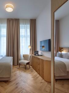 a hotel room with a bed and a mirror at DIALOGUE Boutique Hotel in Brno