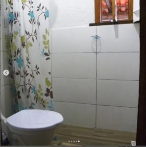 a bathroom with a toilet and a shower curtain at ICE POINT SURF HOUSES Praia do Rosa- Necessário Pré-pagamento Metade Valor Total in Praia do Rosa