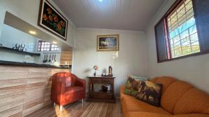 a living room with a couch and a chair at Haras Cristal Experience in Gama