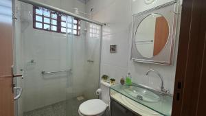 a bathroom with a sink and a shower and a toilet at Haras Cristal Experience in Gama