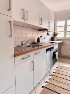 a kitchen with white cabinets and a sink at Panorama Domblick in St. Blasien