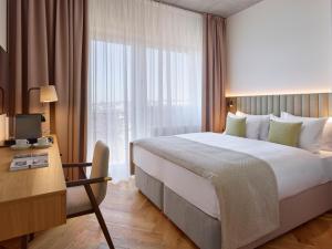 a hotel room with a bed and a desk and a window at DIALOGUE Boutique Hotel in Brno